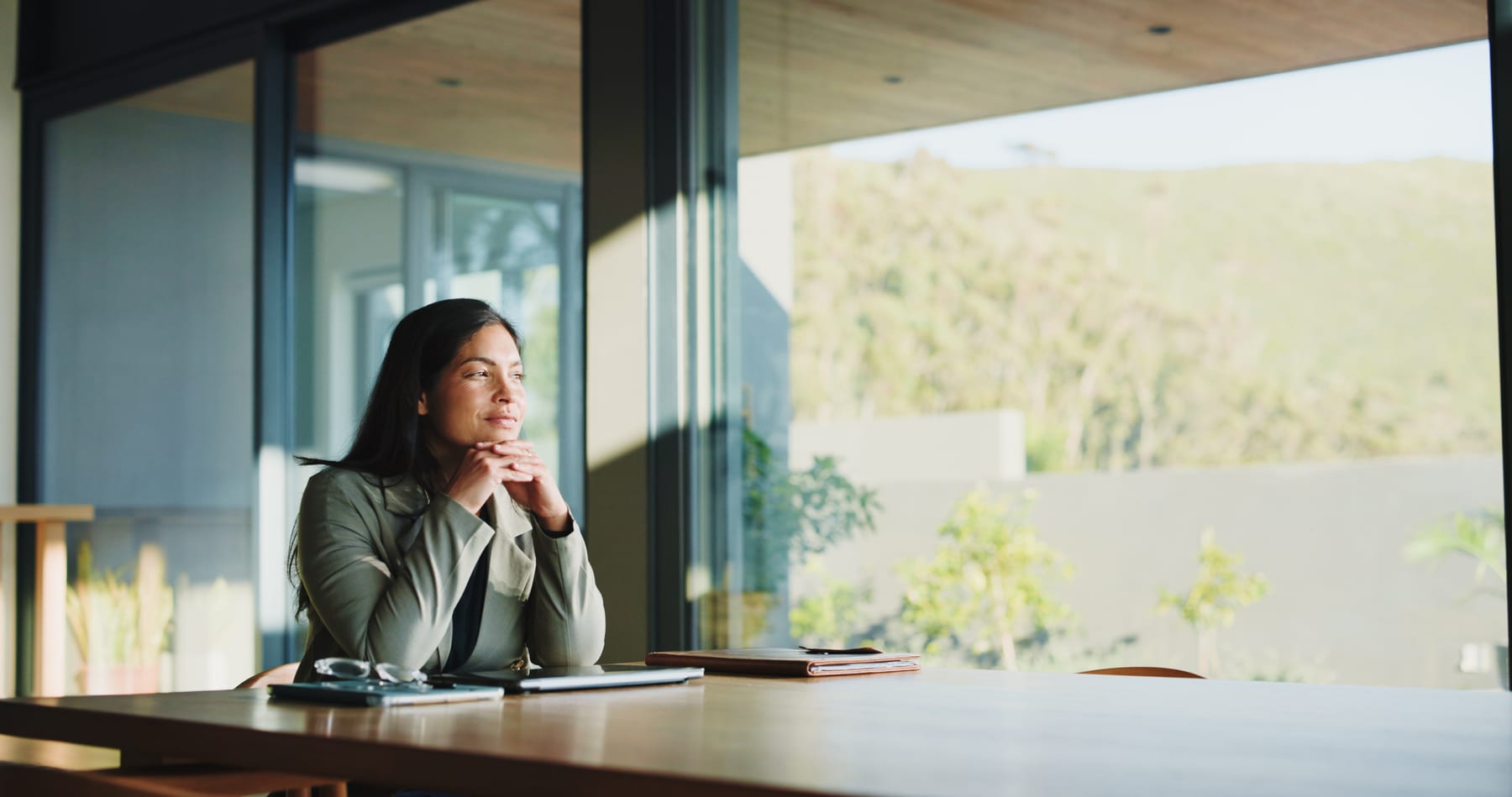 A woman in thoughtful concentration, seated at a desk in natural light