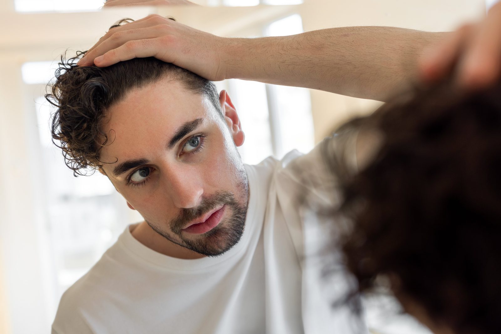 Man looking at his hair in the mirror